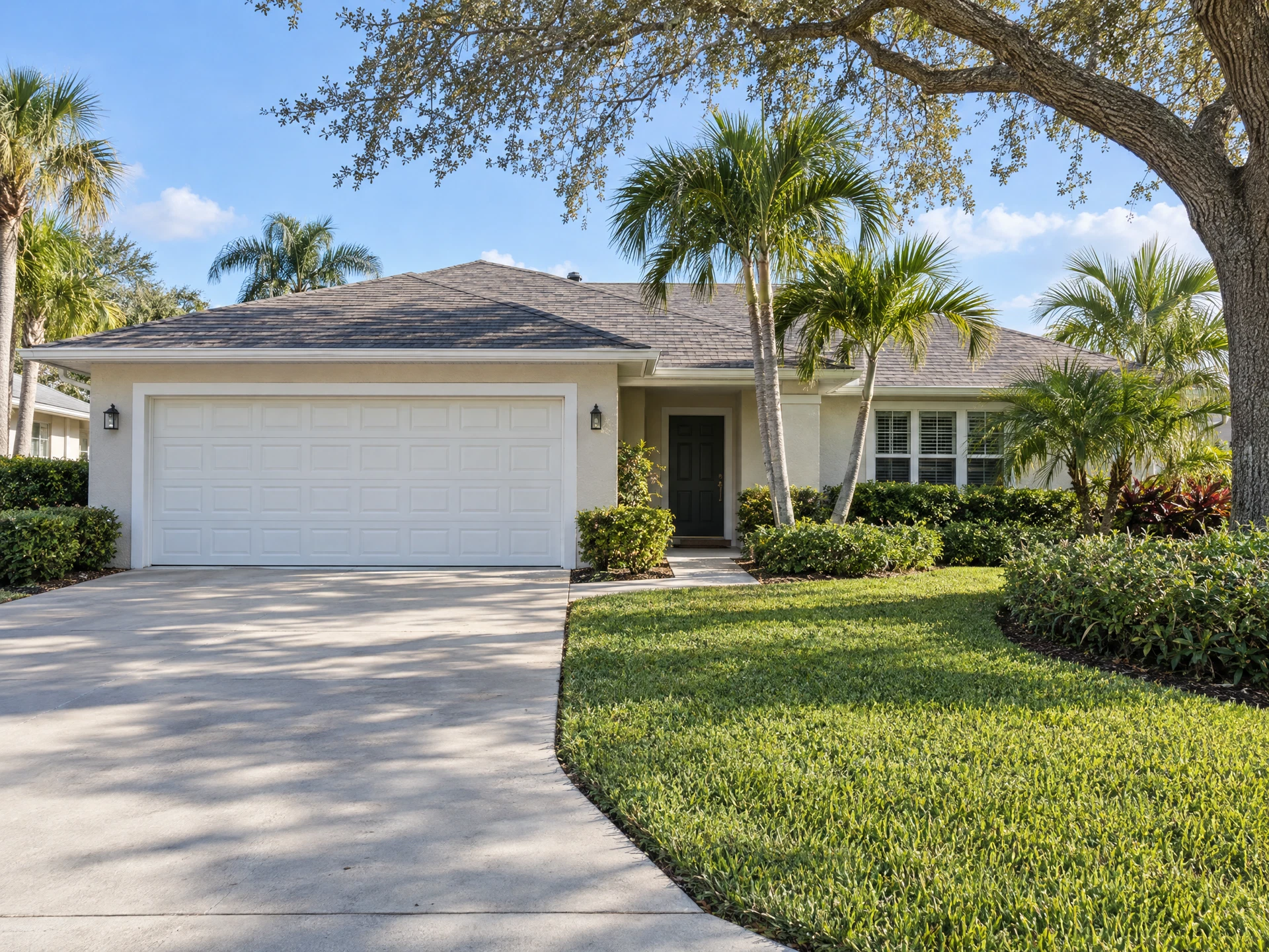 Traditional white raised-panel steel garage door on a Florida ranch home with palm trees
